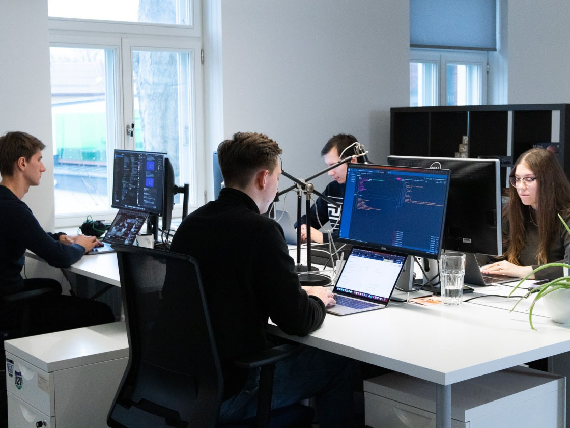 A group of engineers sitting at their tables and working with laptops. 