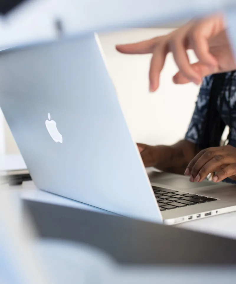 Ein Finger, der auf den Bildschirm des Laptops zeigt.