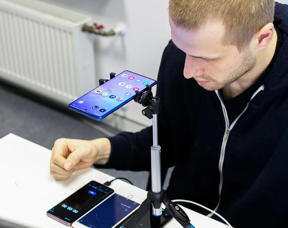 QA-Ingenieur führt manuelle Tests mit 4 verschiedenen mobilen Geräten durch.