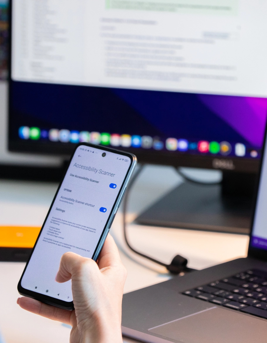 A person sitting at the desk and using a mobile phone.