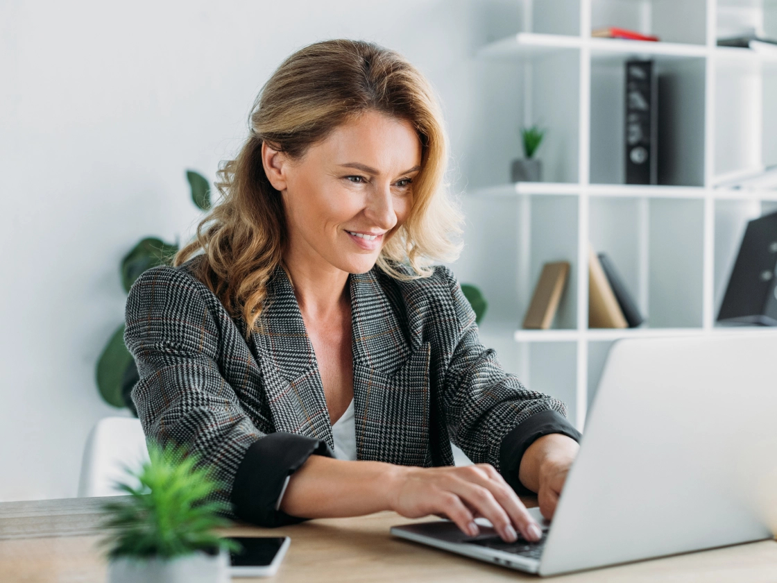 A software quality assurance engineer sitting at the desk and working with a laptop.